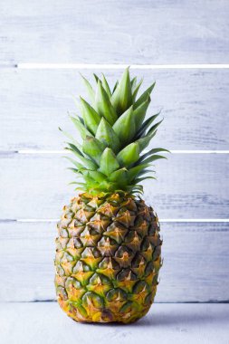 Gri bir arka plan üzerinde ananas. Tahtaların arka planında taze ananas. Vegan için tropikal meyve. Kopyalama alanı