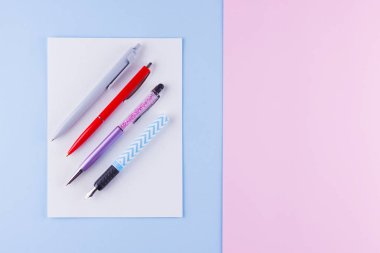 Okul pop art konseptine geri dönelim. Pembe mavi arka plan üzerinde okul kırtasiye. Pastel arka plan üzerinde çok renkli kalemler. Düz yatıyordu. Kopyalama alanı