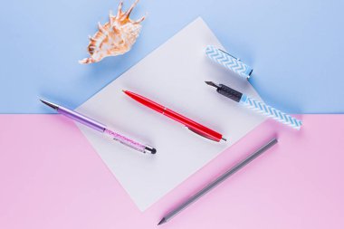 Okul pop art konseptine geri dönelim. Okul kırtasiye ve pembe mavi arka plan üzerinde deniz kabuğu. Pastel arka plan üzerinde çok renkli kalemler. Düz yatıyordu. Kopyalama alanı