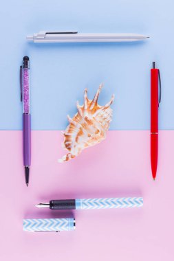 Okul pop art konseptine geri dönelim. Okul kırtasiye ve pembe mavi arka plan üzerinde deniz kabuğu. Pastel arka plan üzerinde çok renkli kalemler. Düz yatıyordu. Kopyalama alanı