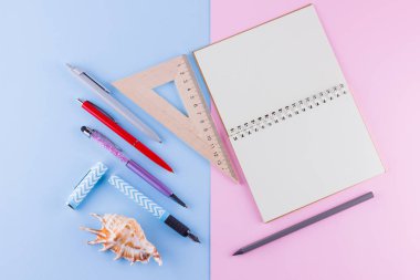 Okul pop art konseptine geri dönelim. Okul kırtasiye ve pembe mavi arka plan üzerinde deniz kabuğu. Pastel arka plan üzerine kalemler, kalem ve gon. Üst te. Kopyalama alanı