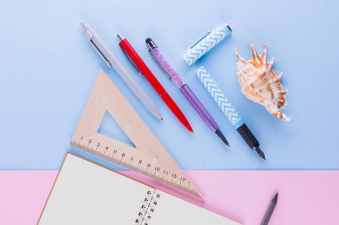 Okul pop art konseptine geri dönelim. Okul kırtasiye ve pembe mavi arka plan üzerinde deniz kabuğu. Pastel arka plan üzerine kalemler, kalem ve gon. Üst te. Kopyalama alanı