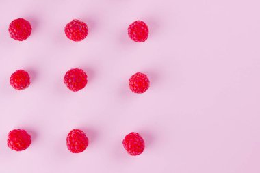 Pembe arka planda ahududu deseni. Renkli diyet ve sağlıklı gıda kavramı. Ahududu arka plan. Üst te. Düz yatıyordu. Kopyalama alanı