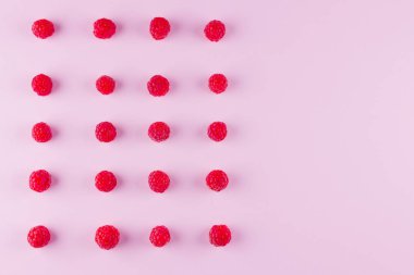 Pembe arka planda ahududu deseni. Renkli diyet ve sağlıklı gıda kavramı. Ahududu arka plan. Üst te. Düz yatıyordu. Kopyalama alanı