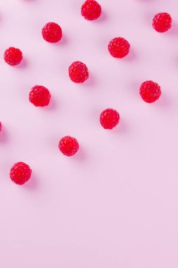 Pembe arka planda ahududu deseni. Renkli diyet ve sağlıklı gıda kavramı. Ahududu arka plan. Üst te. Düz yatıyordu. Kopyalama alanı