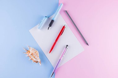 Okul pop art konseptine geri dönelim. Okul kırtasiye ve pembe mavi arka plan üzerinde deniz kabuğu. Pastel arka plan üzerinde çok renkli kalemler. Düz yatıyordu. Kopyalama alanı