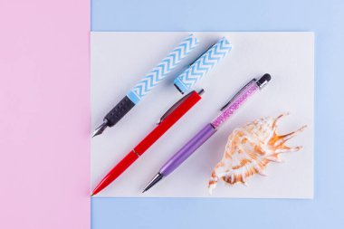 Okul pop art konseptine geri dönelim. Okul kırtasiye ve pembe mavi arka plan üzerinde deniz kabuğu. Pastel arka plan üzerinde çok renkli kalemler. Düz yatıyordu. Kopyalama alanı