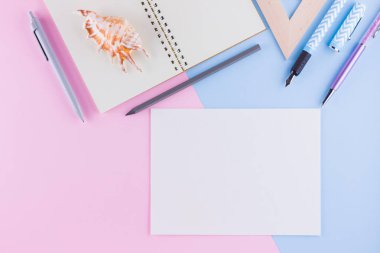 Okul konseptine geri dönelim. Okul kırtasiye ve pembe mavi arka plan üzerinde deniz kabuğu. Pastel arka plan üzerine kalemler, kalem ve gon. Üst te. Kopyalama alanı