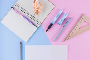 Okul konseptine geri dönelim. Okul kırtasiye ve pembe mavi arka plan üzerinde deniz kabuğu. Pastel arka plan üzerine kalemler, kalem ve gon. Üst te. Kopyalama alanı
