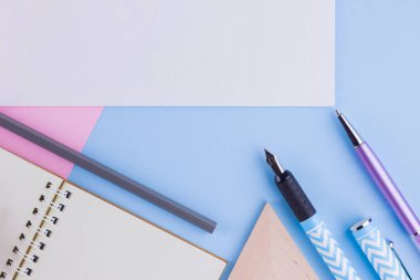 Okul konseptine geri dönelim. Okul kırtasiye ve pembe mavi arka plan üzerinde deniz kabuğu. Pastel arka plan üzerine kalemler, kalem ve gon. Üst te. Kopyalama alanı