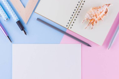 Okul konseptine geri dönelim. Okul kırtasiye ve pembe mavi arka plan üzerinde deniz kabuğu. Pastel arka plan üzerine kalemler, kalem ve gon. Üst te. Kopyalama alanı