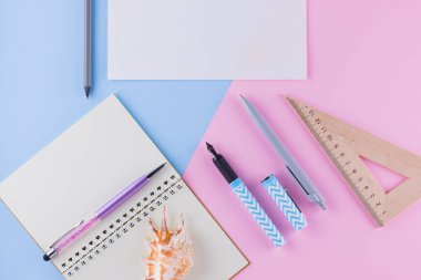 Okul konseptine geri dönelim. Okul kırtasiye ve pembe mavi arka plan üzerinde deniz kabuğu. Pastel arka plan üzerine kalemler, kalem ve gon. Üst te. Kopyalama alanı