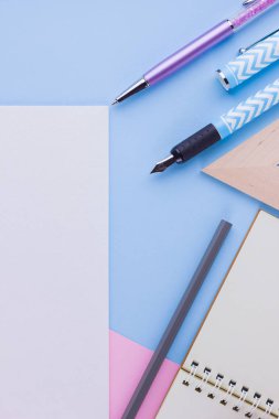 Okul konseptine geri dönelim. Okul kırtasiye ve pembe mavi arka plan üzerinde deniz kabuğu. Pastel arka plan üzerine kalemler, kalem ve gon. Üst te. Kopyalama alanı