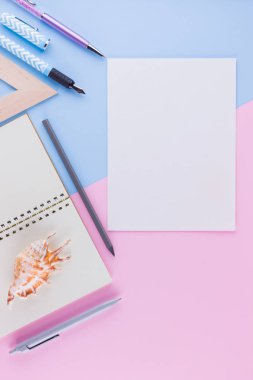 Okul konseptine geri dönelim. Okul kırtasiye ve pembe mavi arka plan üzerinde deniz kabuğu. Pastel arka plan üzerine kalemler, kalem ve gon. Üst te. Kopyalama alanı
