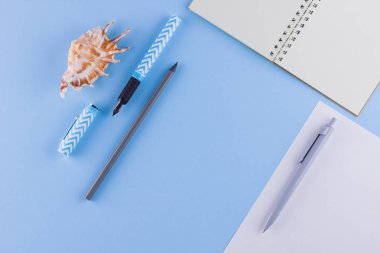 Okul konseptine geri dönelim. Okul kırtasiye ve mavi arka plan üzerinde deniz kabuğu. Pastel arka plan üzerine kalemler, kalem ve gon. Üst te. Kopyalama alanı