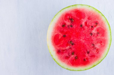 Beyaz arka planda karpuzun yarısı. Açık arka planda dilimlenmiş karpuz. Vegan için sağlıklı bir besin. Üstte görüntü