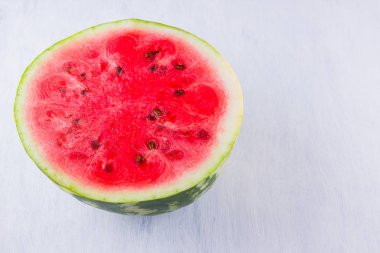 Beyaz arka planda karpuzun yarısı. Açık arka planda dilimlenmiş karpuz. Vegan için sağlıklı bir besin. Üstte görüntü