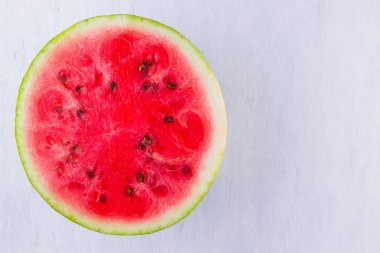 Beyaz arka planda karpuzun yarısı. Açık arka planda dilimlenmiş karpuz. Vegan için sağlıklı bir besin. Üstte görüntü