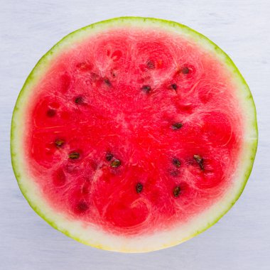 Beyaz arka planda karpuzun yarısı. Açık arka planda dilimlenmiş karpuz. Vegan için sağlıklı bir besin. Üstte görüntü