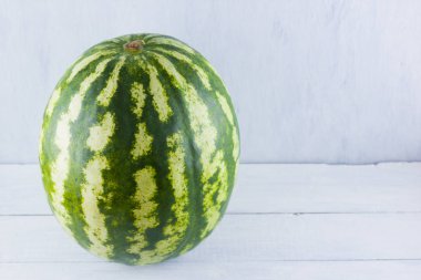 Doğal beyaz arka planda karpuz. Tahta zemin üzerine bütün karpuz. Vegan için sağlıklı bir besin. Kopyalama alanı