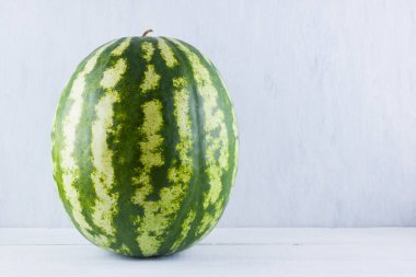 Doğal beyaz arka planda karpuz. Tahta zemin üzerine bütün karpuz. Vegan için sağlıklı bir besin. Kopyalama alanı