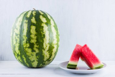 Doğal beyaz arka planda karpuz. Tahta zemin üzerine bütün karpuz. Vegan için sağlıklı bir besin. Kopyalama alanı