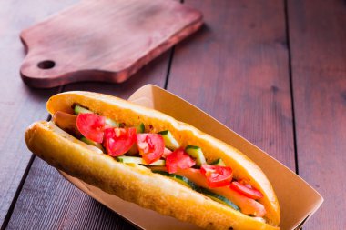 Kağıt kutuda sebzeli ızgara sandviç. Tahta tahtalar üzerinde domates ve salatalık ile Sandviç. Kopyalama alanı