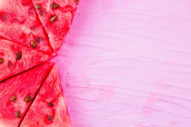 Pembe arka planda karpuz dilimleri. Tohumlu dilimlenmiş karpuz. Yaratıcı gıda konsepti. Üst te. Kopyalama alanı