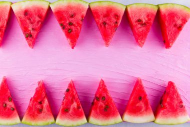 Pembe arka planda karpuz dilimleri. Tohumlu dilimlenmiş karpuz. Yaratıcı gıda konsepti. Üst te. Kopyalama alanı