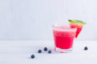 Karpuz, karpuz dilimleri ile bardakta içilir. Beyaz arka planda karpuz smoothies ve yaban mersini. Vejetaryen için yaz sağlıklı içecek. Kopyalama alanı