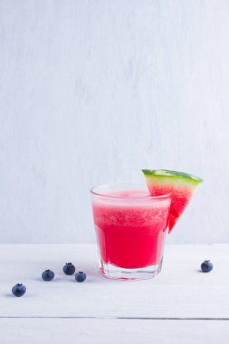 Karpuz, karpuz dilimleri ile bardakta içilir. Beyaz arka planda karpuz smoothies ve yaban mersini. Vejetaryen için yaz sağlıklı içecek. Kopyalama alanı
