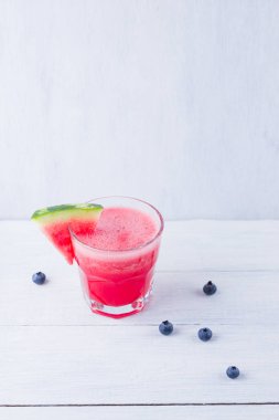 Karpuz, karpuz dilimleri ile bardakta içilir. Beyaz arka planda karpuz smoothies ve yaban mersini. Vejetaryen için yaz sağlıklı içecek. Kopyalama alanı
