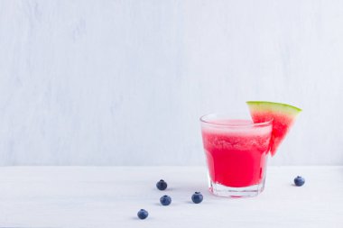 Karpuz, karpuz dilimleri ile bardakta içilir. Beyaz arka planda karpuz smoothies ve yaban mersini. Vejetaryen için yaz sağlıklı içecek. Kopyalama alanı