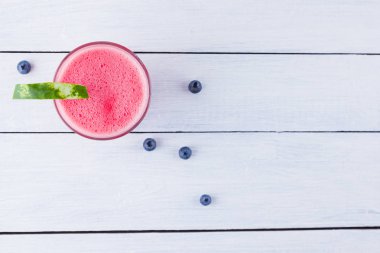 Karpuz, karpuz dilimleri ile bardakta içilir. Beyaz arka planda karpuz smoothies ve yaban mersini. Vejetaryen için yaz sağlıklı içecek. Kopyalama alanı