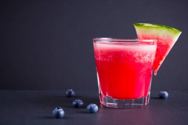 Karpuz, karpuz dilimleri ile bardakta içilir. Karpuz smoothies ve koyu arka plan üzerinde yaban mersini. Vejetaryen için yaz sağlıklı içecek. Kopyalama alanı