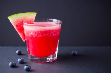 Karpuz, karpuz dilimleri ile bardakta içilir. Karpuz smoothies ve koyu arka plan üzerinde yaban mersini. Vejetaryen için yaz sağlıklı içecek. Kopyalama alanı