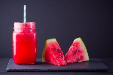 Karpuz karpuz dilimleri ile mason kavanozda karpuz içmek. Karpuz smoothies koyu arka plan üzerinde. Kayrak tahtasında yaz sağlıklı içecek. Kopyalama alanı