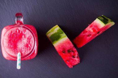 Karpuz karpuz dilimleri ile mason kavanozda karpuz içmek. Karpuz smoothies koyu arka plan üzerinde. Kayrak tahtasında yaz sağlıklı içecek. Kopyalama alanı