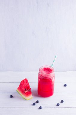 Karpuz dilimleri ile mason kavanozlarda karpuz içmek. Beyaz arka planda karpuz smoothies ve yaban mersini. Vejetaryen için yaz sağlıklı içecek. Kopyalama alanı