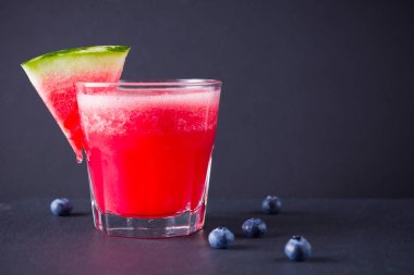 Karpuz, karpuz dilimleri ile bardakta içilir. Karpuz smoothies ve koyu arka plan üzerinde yaban mersini. Vejetaryen için yaz sağlıklı içecek. Kopyalama alanı
