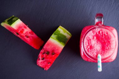 Karpuz karpuz dilimleri ile mason kavanozda karpuz içmek. Karpuz smoothies koyu arka plan üzerinde. Kayrak tahtasında yaz sağlıklı içecek. Kopyalama alanı