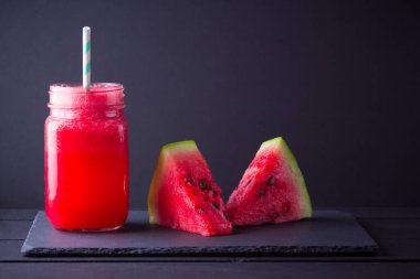 Karpuz karpuz dilimleri ile mason kavanozda karpuz içmek. Karpuz smoothies koyu arka plan üzerinde. Kayrak tahtasında yaz sağlıklı içecek. Kopyalama alanı