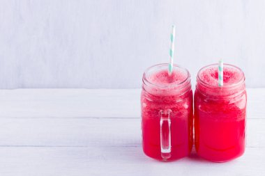Karpuz dilimleri ile mason kavanozlarda karpuz içmek. Beyaz arka planda karpuz smoothies ve yaban mersini. Vejetaryen için yaz sağlıklı içecek. Kopyalama alanı
