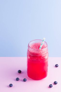 Karpuz dilimleri ile mason kavanozda karpuz smothie. Pembe mavi arka plan üzerinde karpuz smoothies ve yaban mersini. Vegan için sağlıklı bir içecek. Kopyalama alanı