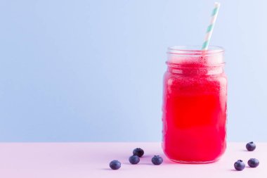 Karpuz dilimleri ile mason kavanozda karpuz smothie. Pembe mavi arka plan üzerinde karpuz smoothies ve yaban mersini. Vegan için sağlıklı bir içecek. Kopyalama alanı