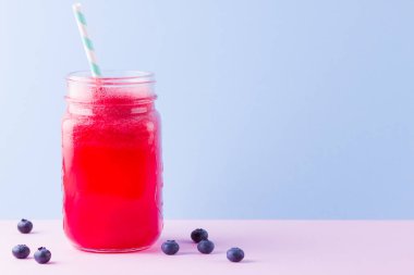 Karpuz dilimleri ile mason kavanozda karpuz smothie. Pembe mavi arka plan üzerinde karpuz smoothies ve yaban mersini. Vegan için sağlıklı bir içecek. Kopyalama alanı