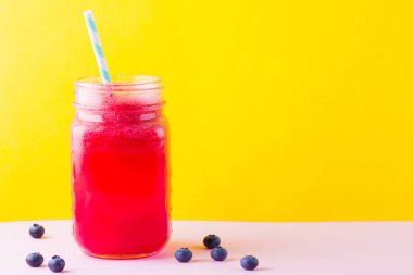 Karpuz dilimleri ile mason kavanozda karpuz smothie. Pembe sarı arka plan üzerinde karpuz smoothies ve yaban mersini. Vegan için sağlıklı içecek