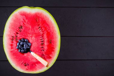 Karpuz ve koyu arka planda yaban mersini. Karpuzda yaban mersini. Yaratıcı gıda konsepti. Üstte görüntü