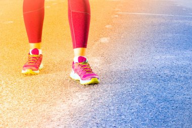 Spor ayakkabıyla koşan sportif kadın, degrade. Koşucu ayakları yolda koşuyor ayakkabıya yakın. Genç fitness kadın çalışan, tonda. Fitness ve egzersiz sağlıklı yaşam konsepti