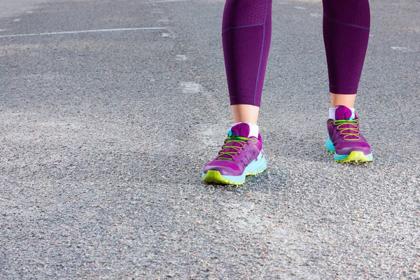 Sporty woman running in sneakers. Runner feet running on road close up on shoe. Young fitness woman running on morning. Fitness and workout wellness concept